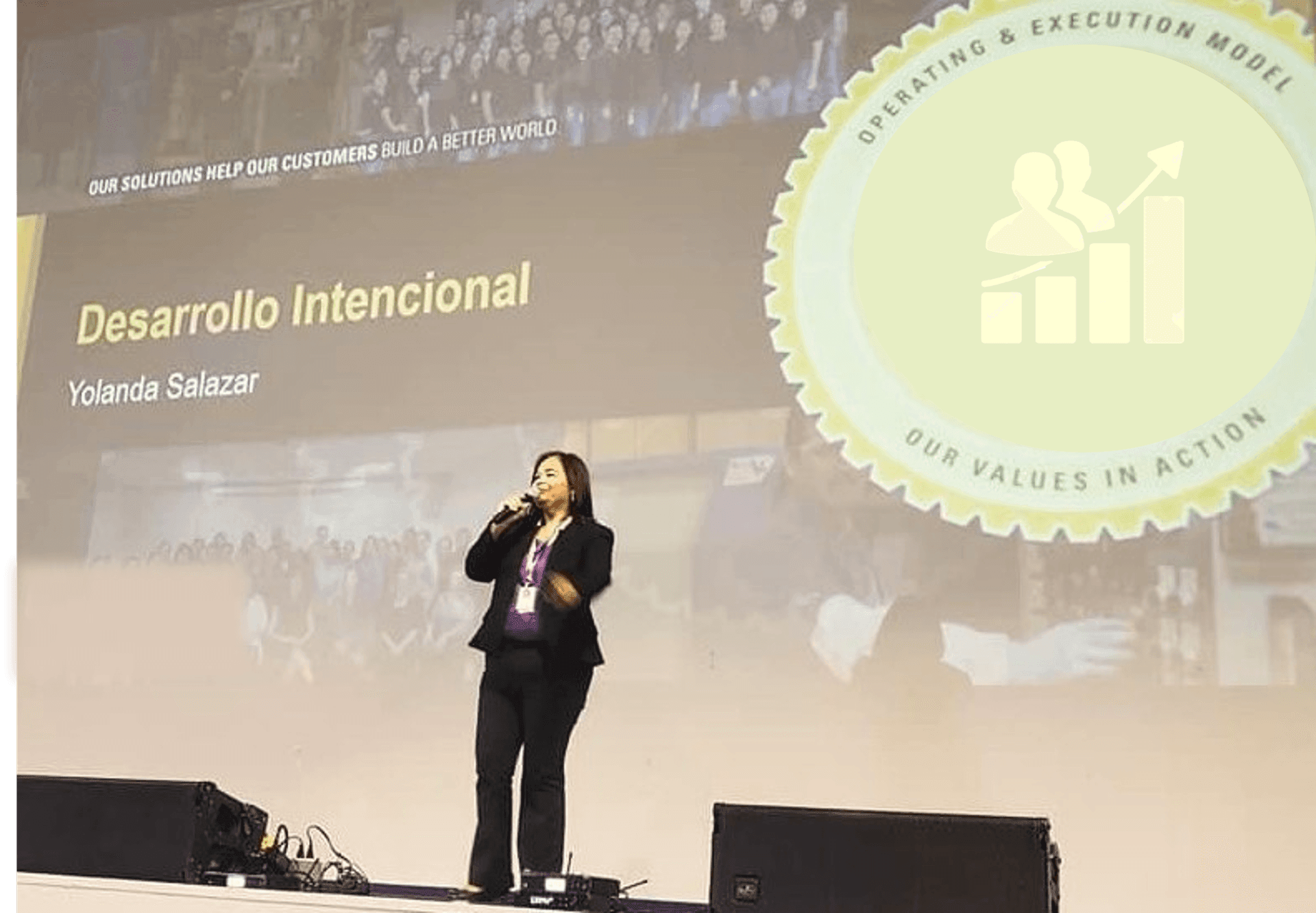 Speaker on stage presenting 'Desarrollo Intencional' with graphics in background at a conference.